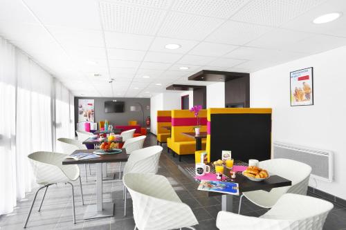 a dining room with white chairs and tables and yellow chairs at Résidence Néméa Aix Campus 1 in Aix-en-Provence