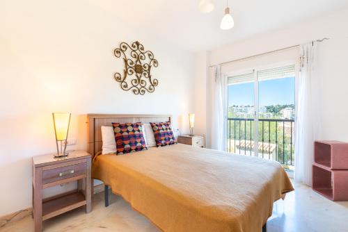 a bedroom with a large bed and a window at Modern Apartment in Jardin Botanico in La Cala de Mijas