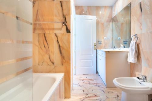 a bathroom with a tub and a sink and a toilet at Modern Apartment in Jardin Botanico in La Cala de Mijas