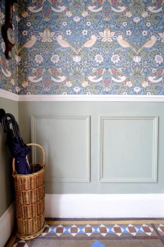 a wicker basket next to a wall with wallpaper at Kingsway Guest House in Edinburgh