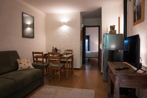 a living room with a couch a table and a refrigerator at bb26 apartment mountain Lozio in Lozio
