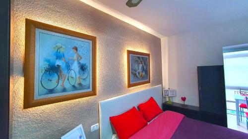 a bedroom with a bed with red pillows and a painting at PRINCIPADO A in Puerto de la Cruz