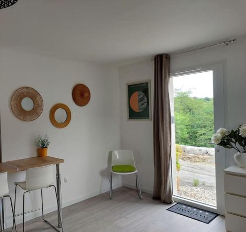 a dining room with a table and a window at Les Côteaux de la Grange in Mercuer