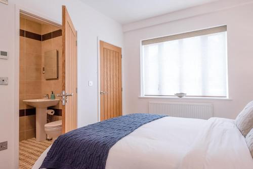 a white bedroom with a bed and a sink at Guild House, Aldeburgh in Aldeburgh