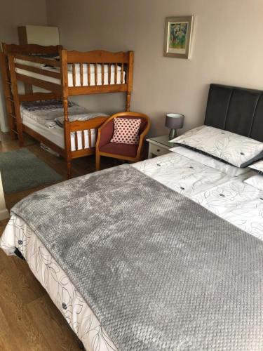 a bedroom with two twin beds and a chair at The Annexe Room Hea Close in Penzance