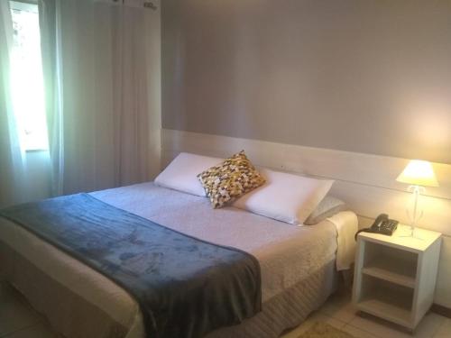 a small bedroom with a bed with a phone on it at Pousada Matitaterê in Teresópolis