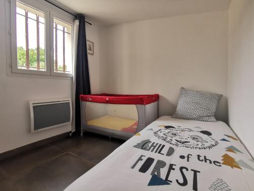une petite chambre avec un lit et une chaise rouge dans l'établissement Maison de vacances L'Hôte Champêtre campagne arlésienne, à Arles