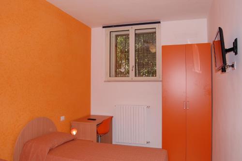 Habitación pequeña con cama y ventana en B&B Fenix, en Trani