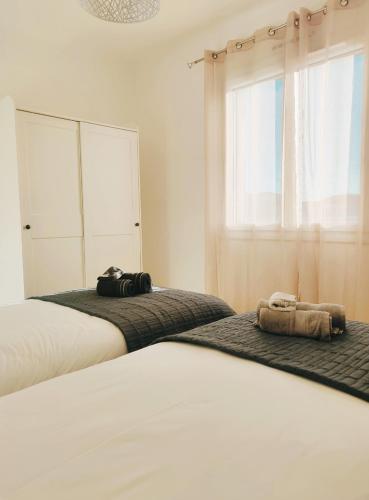 une chambre avec deux lits et une fenêtre dans l'établissement Villa Marie-Josée, au Muy