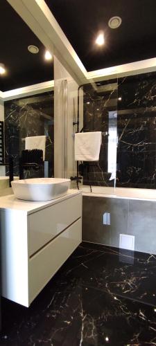 a bathroom with a sink and black marble walls at Nova Stodola in Kłomnice