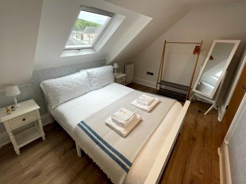 a bedroom with a bed with two towels on it at Pass the Keys Beautifully Presented 3BR Luxury Apartment in Kirkcudbright