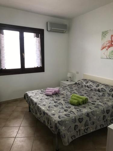 sypialnia z łóżkiem z dwoma zielonymi ręcznikami w obiekcie Olbia House w mieście Olbia