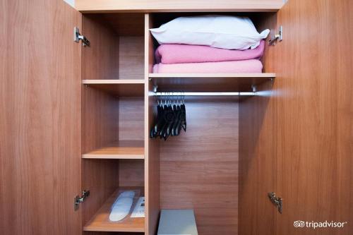 a closet with wooden cabinets and towels in it at Rho Hotel in Amsterdam