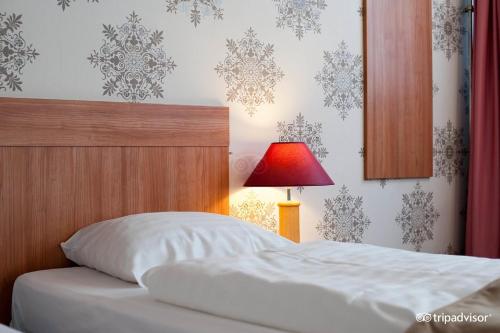 a bedroom with a bed and a red lamp at Rho Hotel in Amsterdam