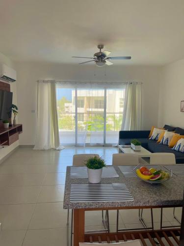 a living room with a table and a blue couch at Vista Golf Playa Nueva Romana in La Romana