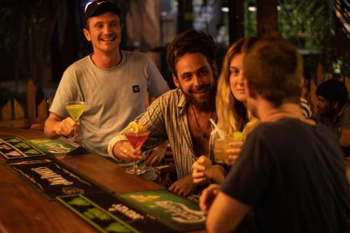 a group of people sitting at a bar with drinks at Tuk Tuk Boutique Hotel in Negombo