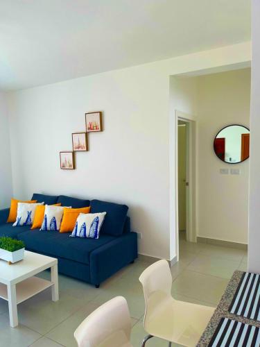 Vista Golf Playa Nueva Romana في لا رومانا: غرفة معيشة مع أريكة زرقاء وطاولة