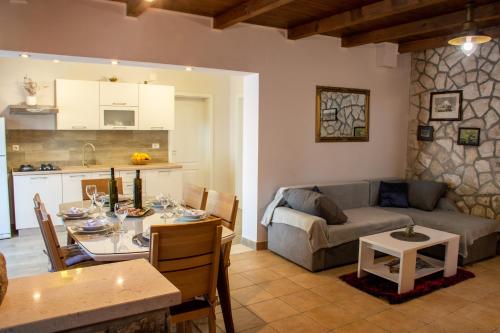 a kitchen and a living room with a table and a couch at Holiday Home Luna in Blato