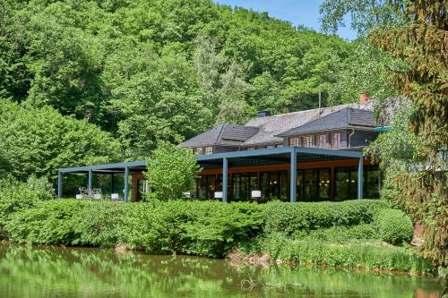 a house on the side of a river at Land-gut-Hotel Forellenhof in Bundenbach