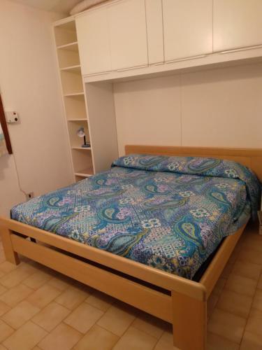 a bedroom with a bed with a blue comforter at Villetta Kala E Moru Sa oghe e su mare in Geremèas