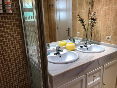 a bathroom with two sinks and a mirror at Comfy apartment in the heart of the Costa del Sol in Mijas Costa