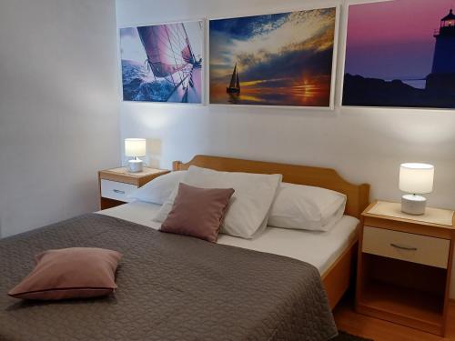 1 dormitorio con 1 cama con 2 lámparas y cuadros en la pared en Apartments Marion Klenovica, en Klenovica