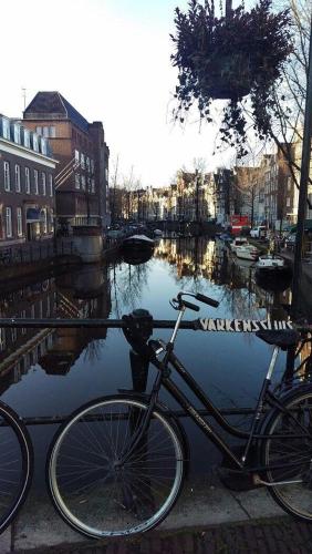 a bike parked next to a canal with boats at Rho Hotel in Amsterdam