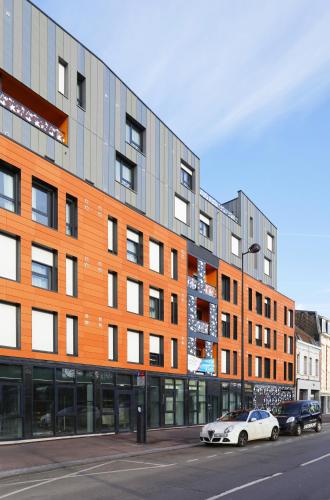 un bâtiment dans une rue avec des voitures garées devant dans l'établissement Résidence Nemea Roubaix Eurotéléport, à Roubaix