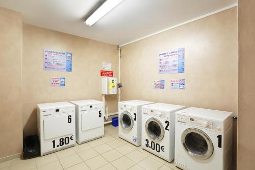 a laundry room with three washer and dryers at Résidence Néméa Roubaix in Roubaix