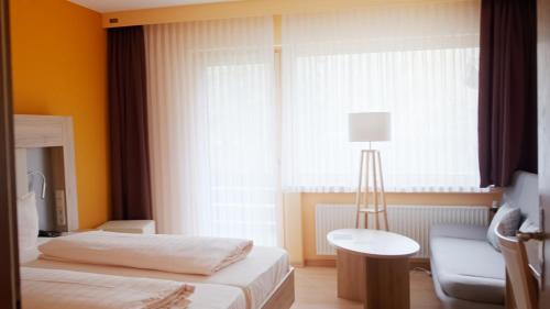 a hotel room with two beds and a window at Land-gut-Hotel Forellenhof in Bundenbach