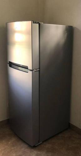 a large stainless steel refrigerator in a room at Kelly's Studio Apartment - Rental near Airport, Amenities and Bus Route in Saint Philip