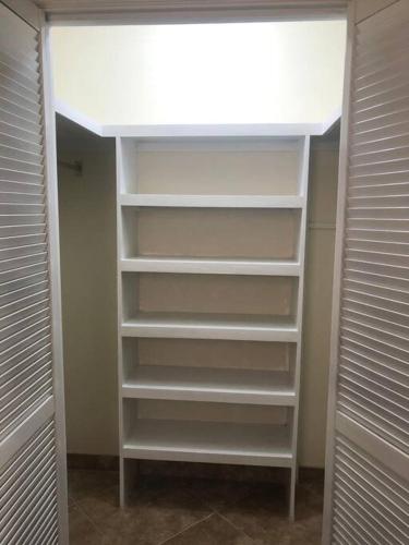 a walk in closet with white shelves and a ceiling at Kelly's Studio Apartment - Rental near Airport, Amenities and Bus Route in Saint Philip