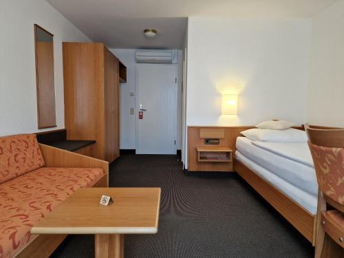a hotel room with a bed and a couch at Hotel Gerberhof in Backnang