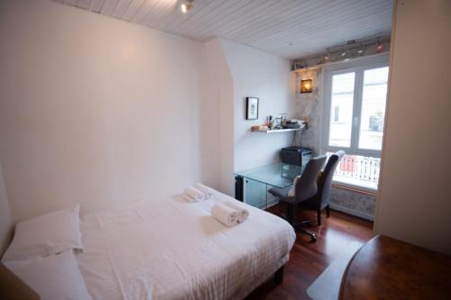 a bedroom with a bed and a desk and a window at Cozy 1 Bedroom Apartment In 14th in Paris