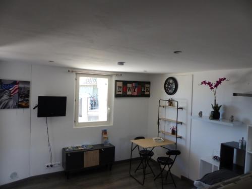 a living room with a table and a window at Studio le Nimhotep tout équipé in Briançonnet