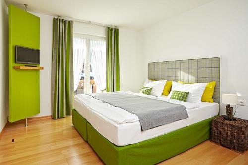 - une chambre avec un grand lit aux accents verts dans l'établissement Alpenflair Ferienwohnungen Gästehaus Hilbrand Whg 313,314,215, à Oberstdorf
