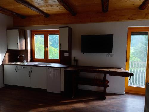 a kitchen with a counter and a tv on the wall at Lahova hiša in Ljubno