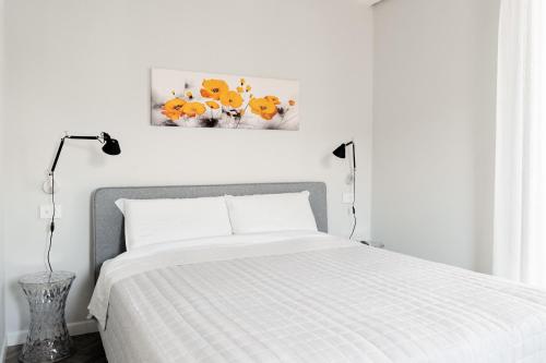 a white bedroom with a bed and a painting on the wall at HomeThirtyFour in Verona