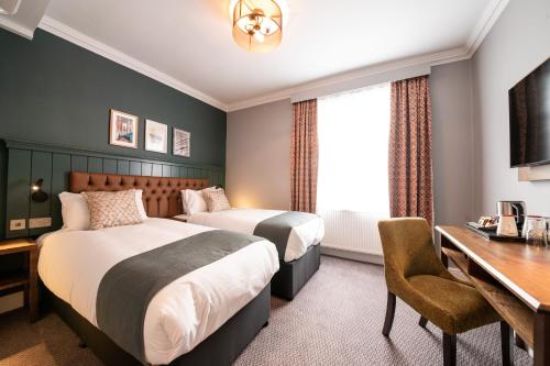 a hotel room with two beds and a desk at The Mitre by Innkeeper's Collection in London