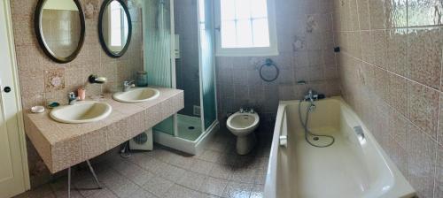 a bathroom with two sinks and a tub and a toilet at Le refuge des canards in Saint-Aubin-le-Cloud