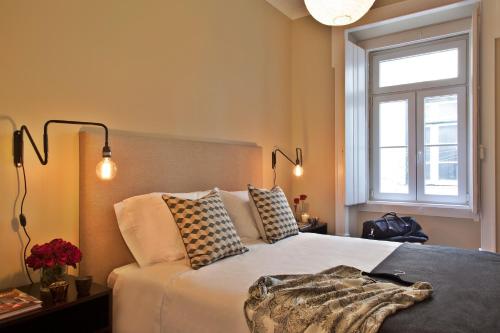 a bedroom with a bed with pillows and a window at Lisbon Five Stars Apartments São Julião 72 in Lisbon