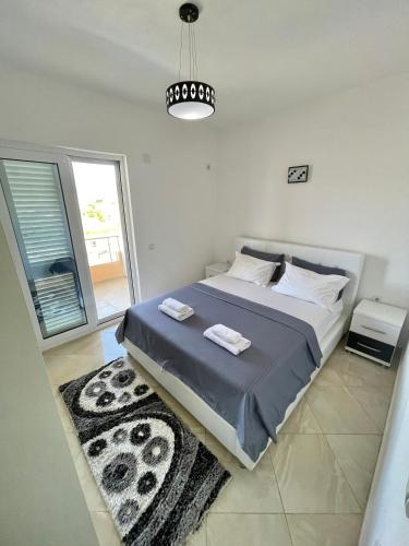a bedroom with a bed with two towels on it at Queen Kodre Apartments in Ulcinj