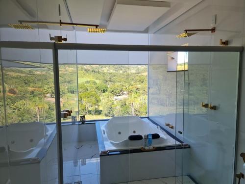 a bathroom with two sinks and a large window at Pousada Descobrindo a Vida in Brumadinho