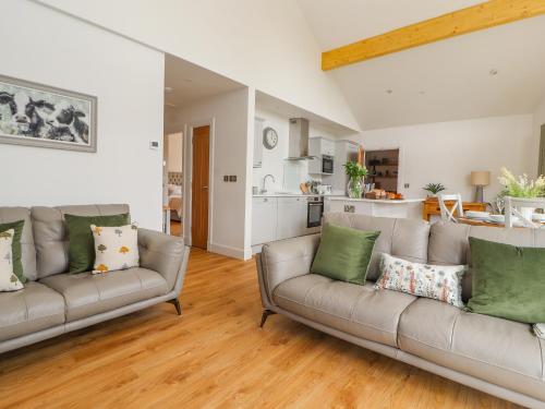 a living room with two couches and a kitchen at Pen Bryn in Ruthin