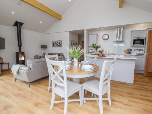 a kitchen and living room with a table and chairs at Pen Bryn in Ruthin
