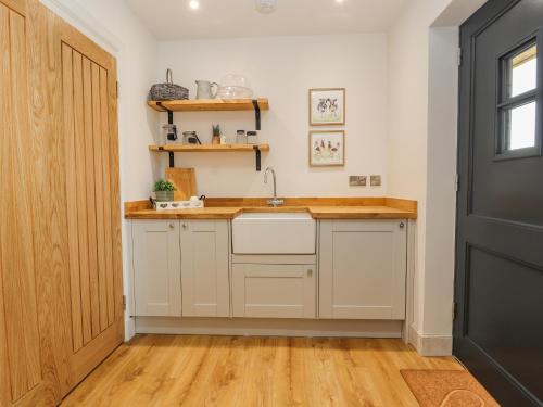 a kitchen with a sink and a wooden floor at Pen Bryn in Ruthin