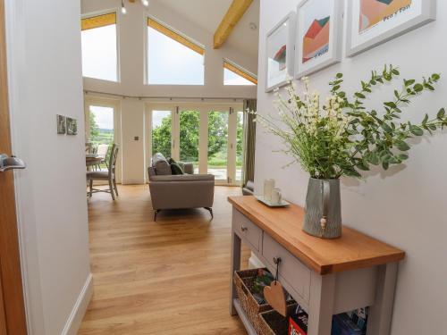 a living room with a vase of flowers on a table at Pen Bryn in Ruthin