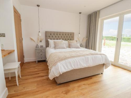 a bedroom with a large bed and a large window at Pen Bryn in Ruthin