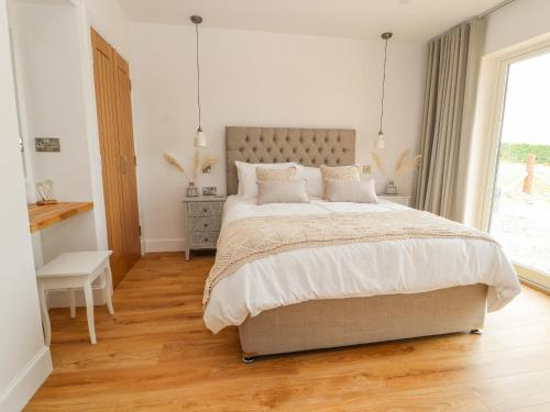 a bedroom with a large bed and a window at Pen Bryn in Ruthin