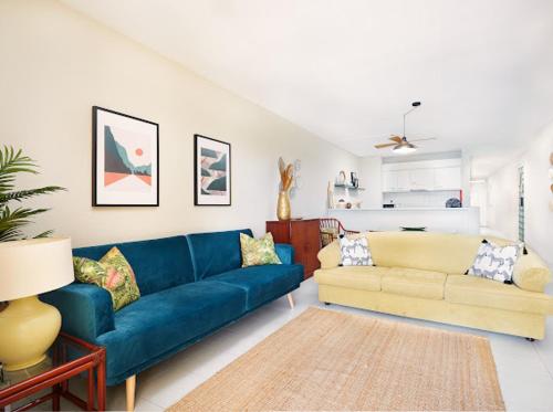 un soggiorno con divano blu e divano giallo di Lovely apartment with pool and sea view a Funchal